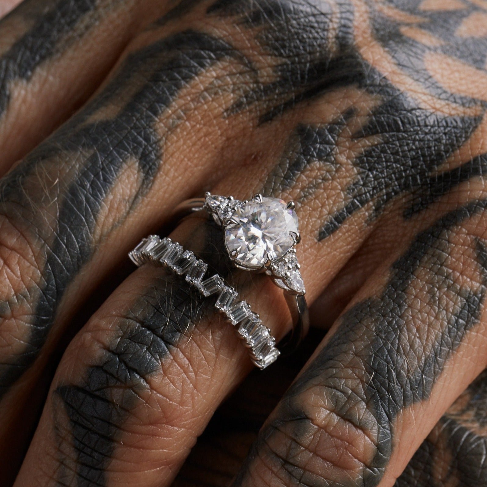 yoki oval lab diamond with pear accents on side white gold on tattooed bride